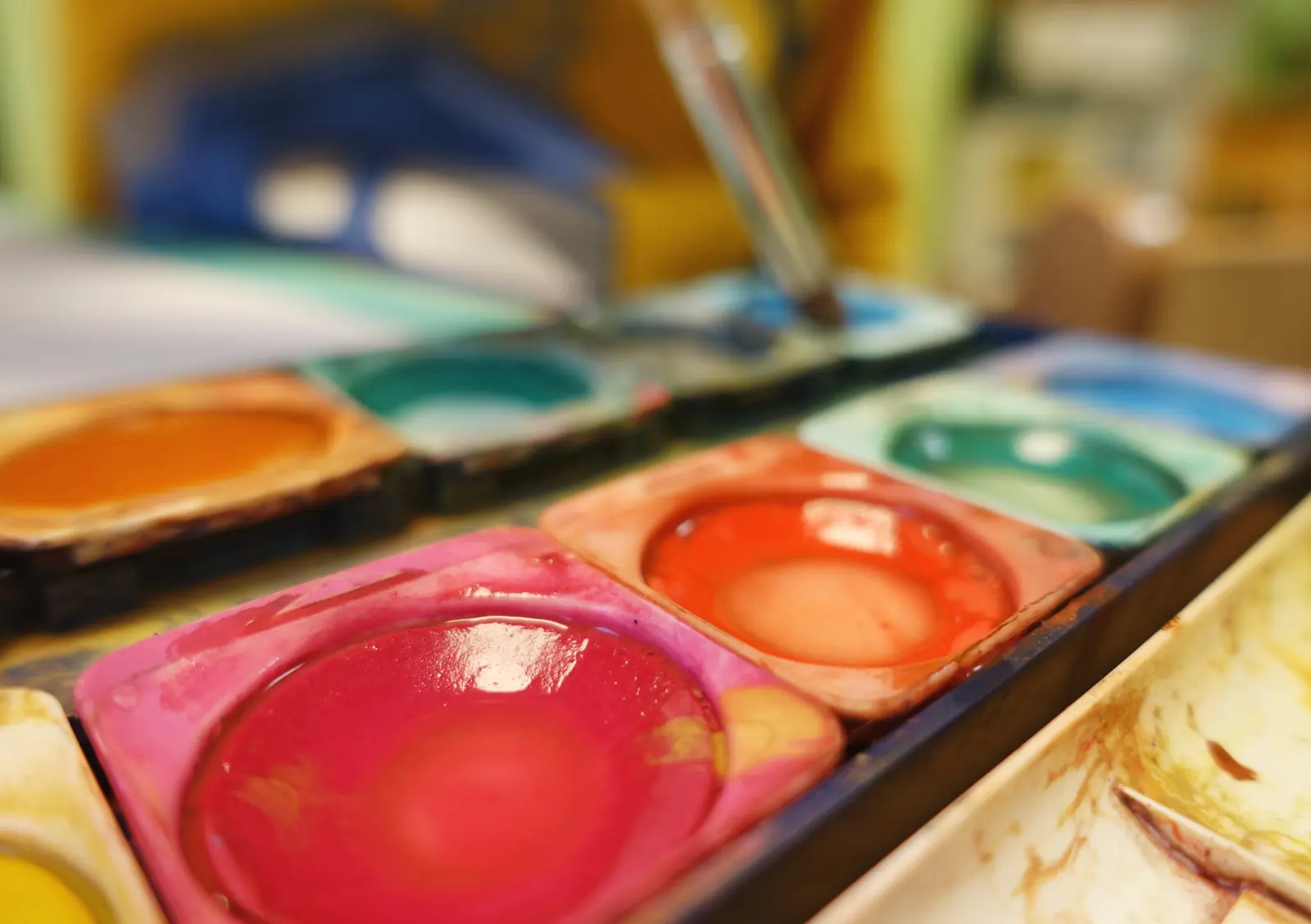 Ein Tuschkasten mit bunten Farben und Pinsel